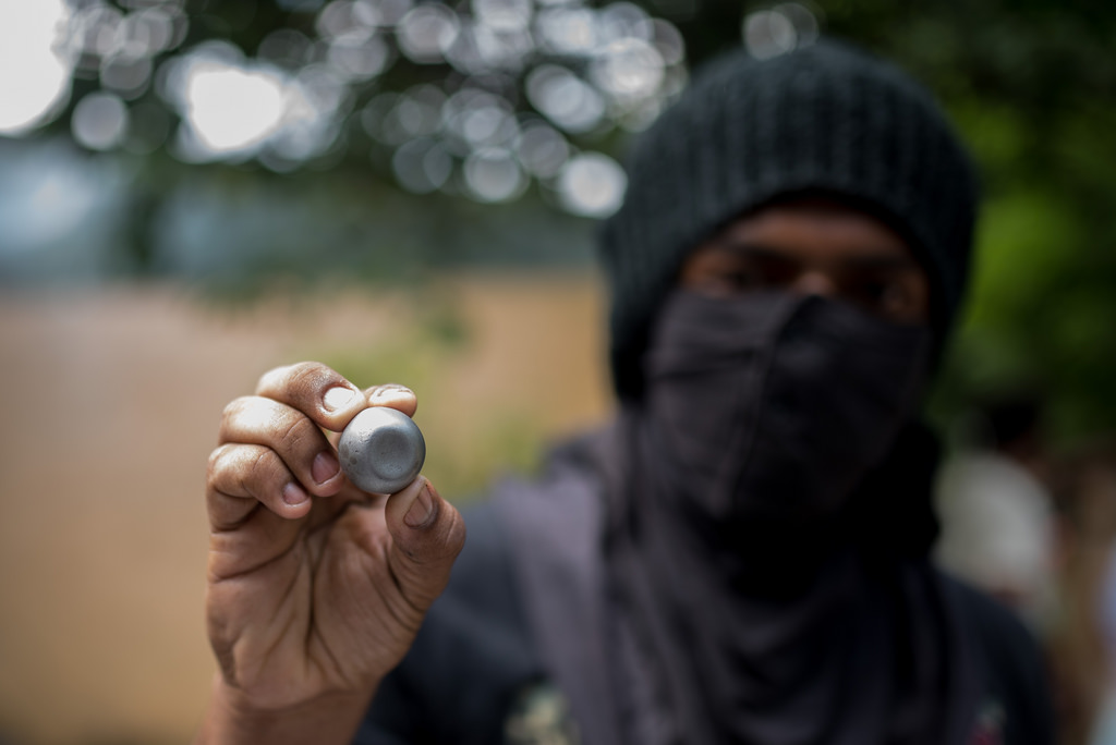 Un estudiante muestra uno de los balines que usaron las fuerzas paramilitares en el enfrentamiento. Foto Carlos Herrera