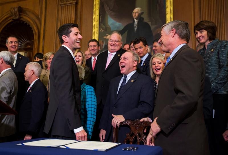 El presidente de la Cámara de Representantes el republicano por Wisconsin Paul Ryan (i) se ríe con los congresistas republicanos Steve Scales (c) y Fred Uptown (d) después de firmar la revocatoria para el programa de salud del presidente de EEUU Barack Obama. EFE