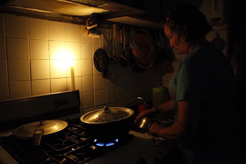 Una mujer cocina con gas durante un corte de luz en San Cristobal, Venezuela. EFE