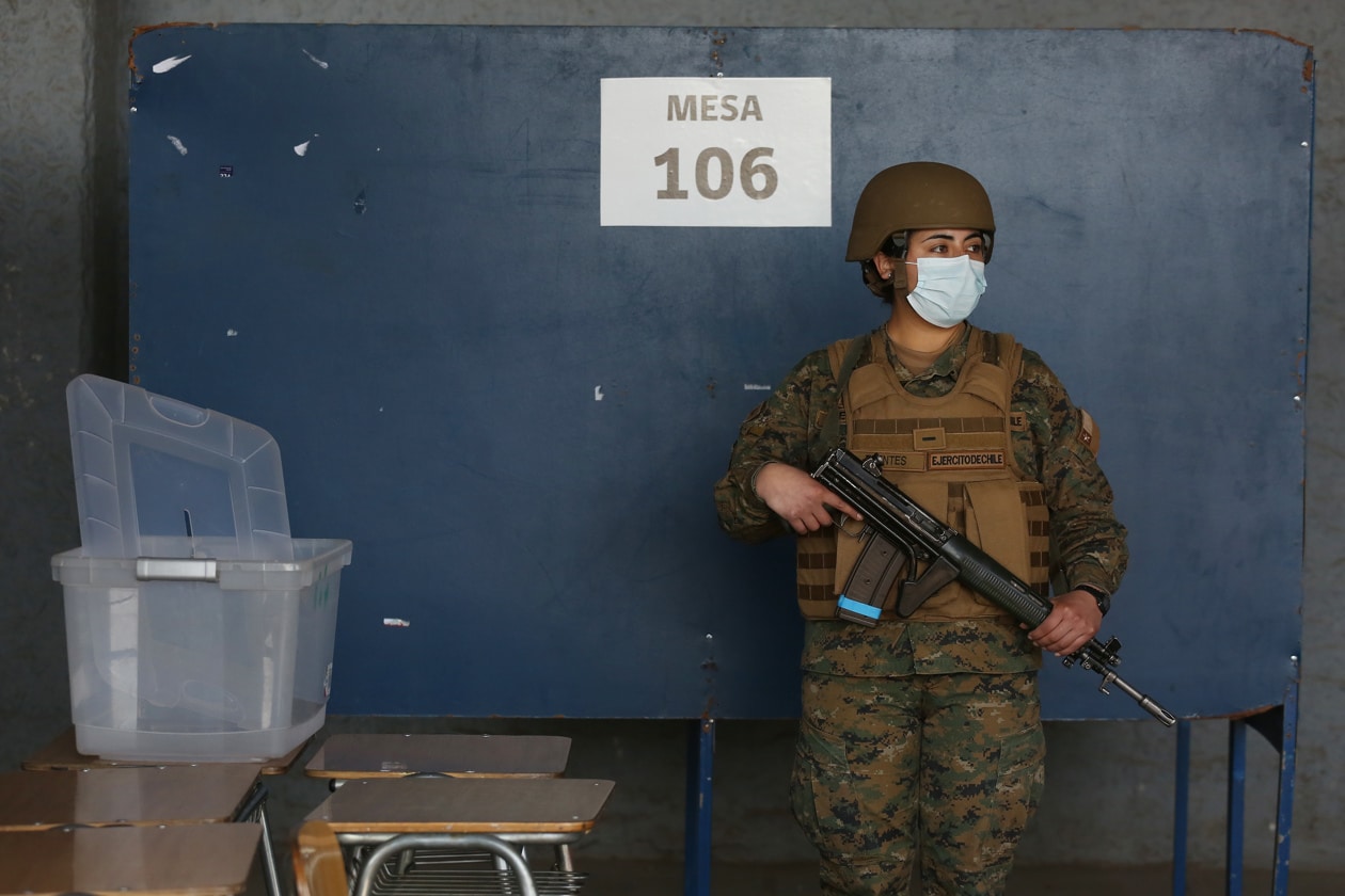 A soldier stands guard while a polling station is installed for the constitutional plebiscite at the National Stadium in Santiago, Chile. Photo: EFE/Elvis González