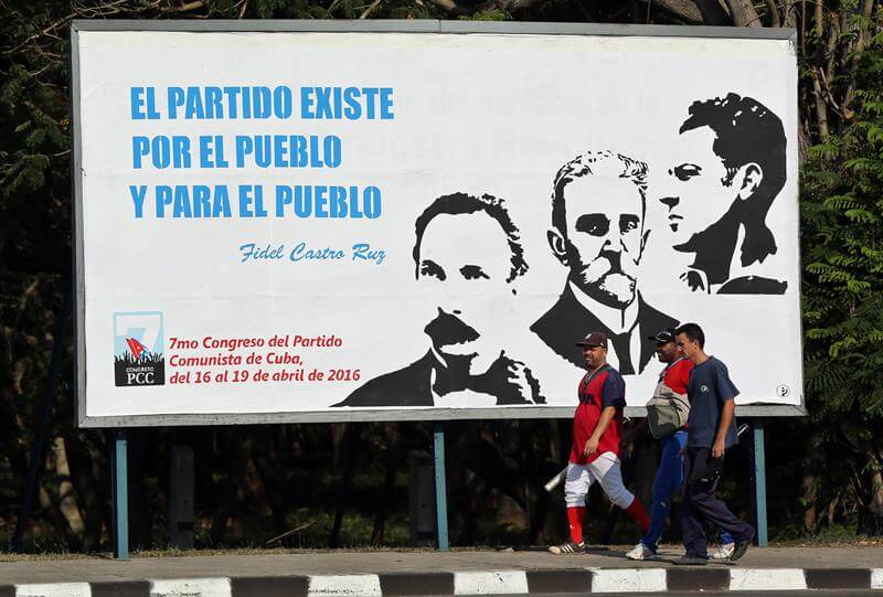 Tres hombres caminan junto a un cartel alusivo al VII Congreso del Partido Comunista de Cuba, hoy sábado 16 de abril, en La Habana (Cuba).  EFE/Alejandro Ernesto
