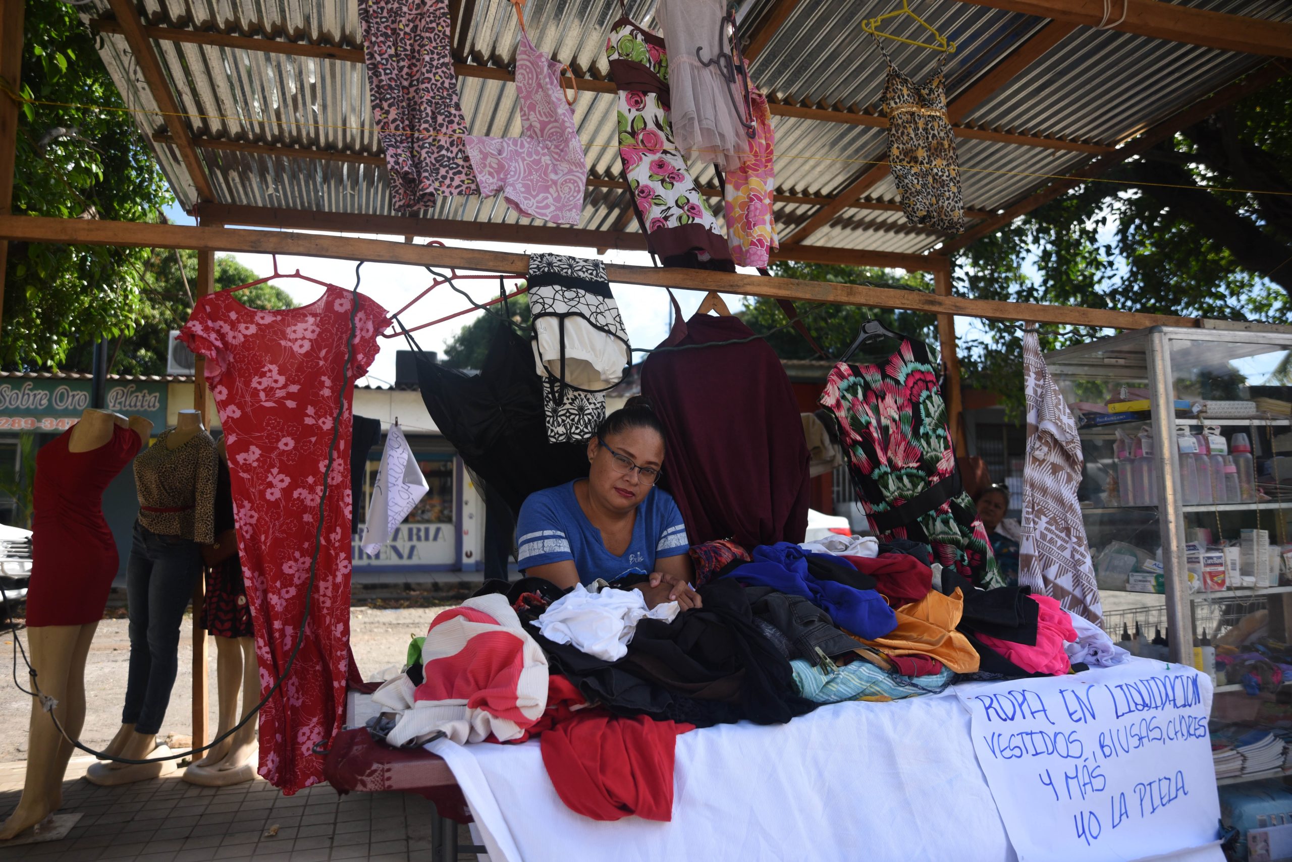 Patricia Urbina vendía ropa usada en la entrada de su casa, pero la falta de clientes la obligó a trasladarse a la calle principal de la colonia Primero de Mayo. // Foto: Nayira Valenzuela | Confidencial