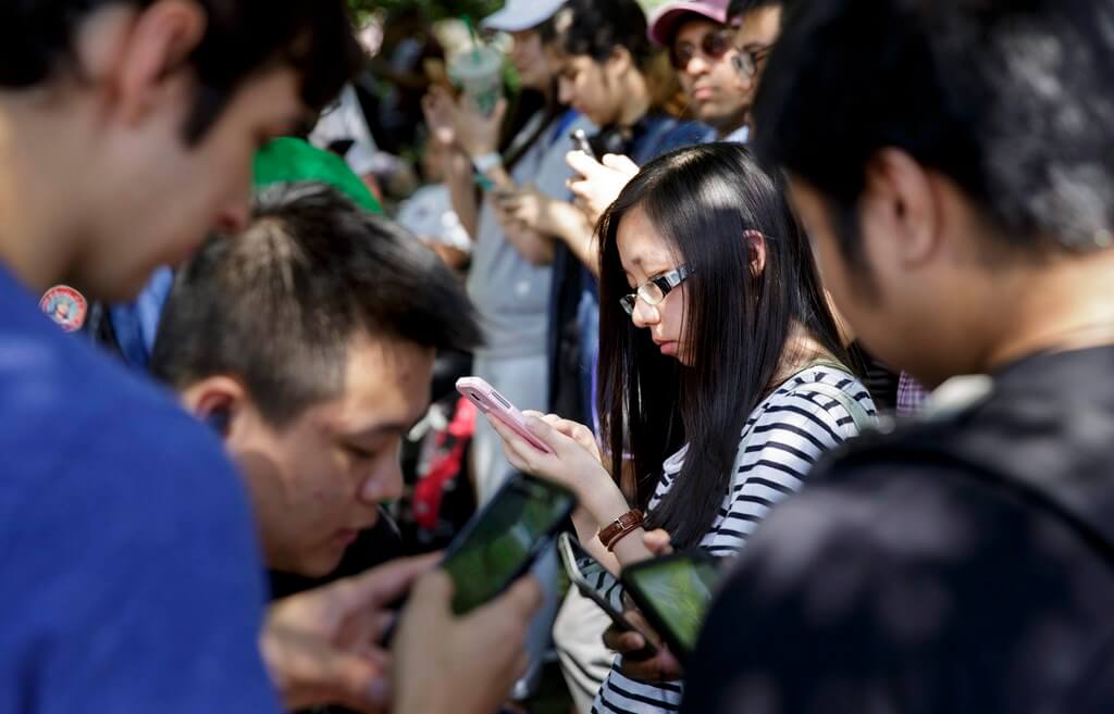 Jóvenes se entretienen con el videojuego 'Pokemon Go' en sus teléfonos inteligentes en Union Square. EFE/JUSTIN LANE