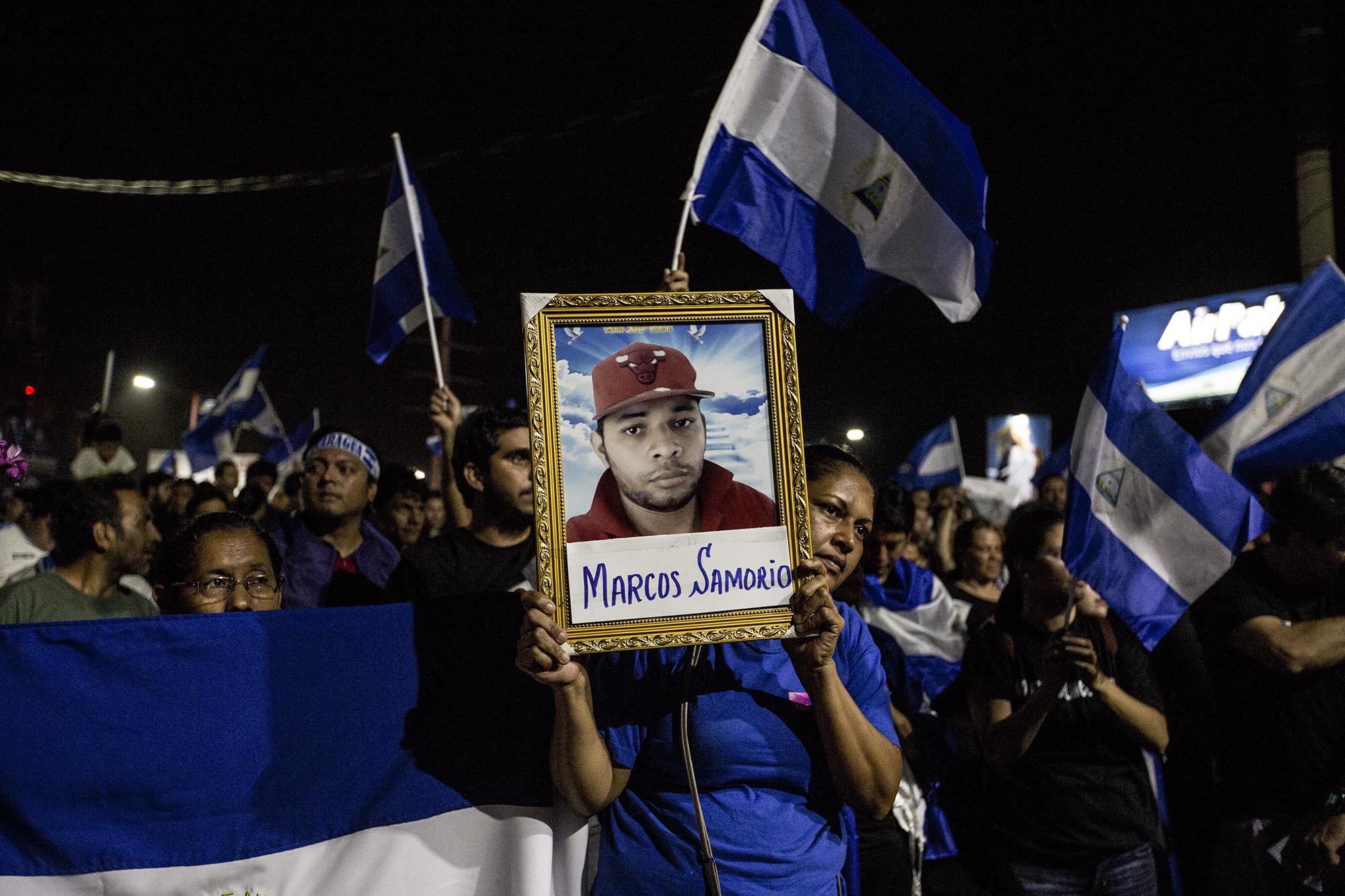 La tía de Marcos Samorio levanta un retrato de su sobrino, asesinado el 20 de abril por grupos de choque a favor del régimen de Daniel Ortega. Foto: Fred Ramos